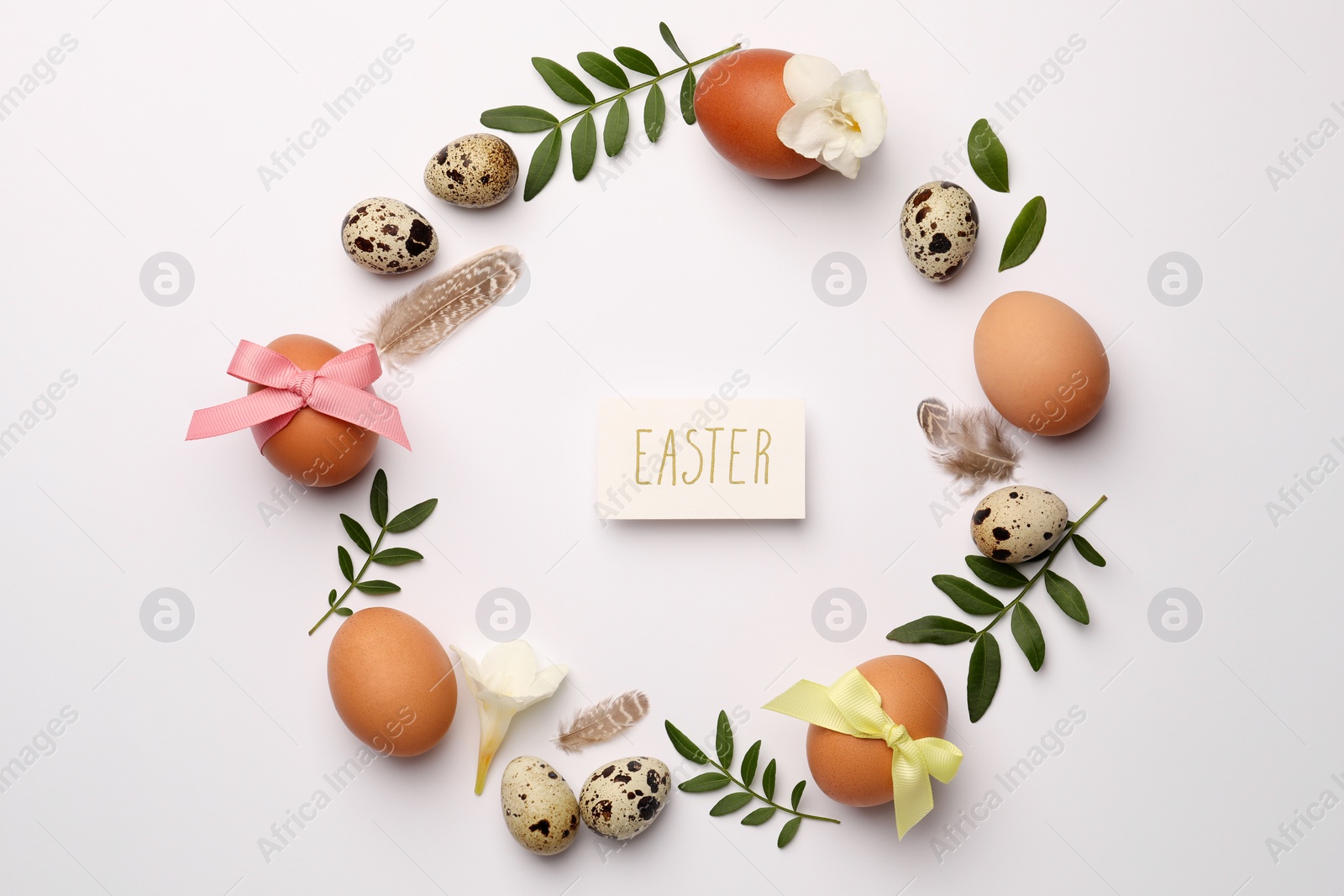 Photo of Card with word Easter and frame of different eggs and twigs on white background, flat lay