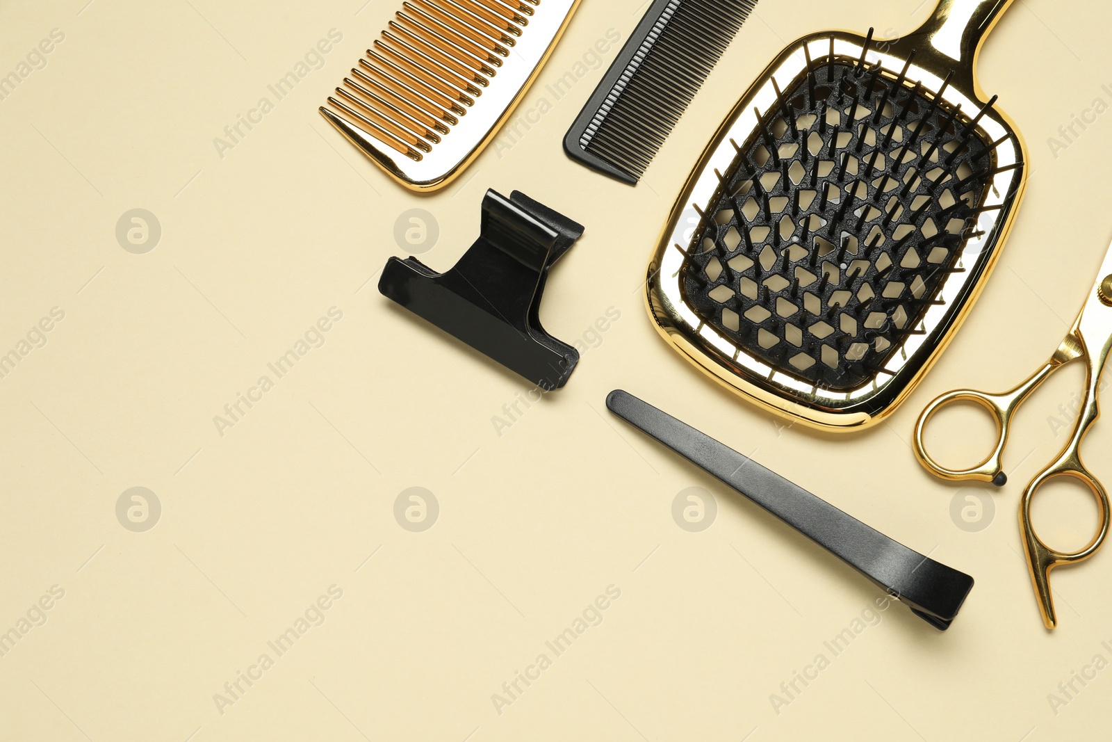 Photo of Hairdressing tools on beige background, flat lay. Space for text