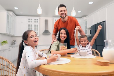 Photo of Happy family with children having fun during breakfast at home