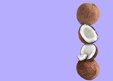 Image of Stack of fresh coconuts on pale violet background. Space for text