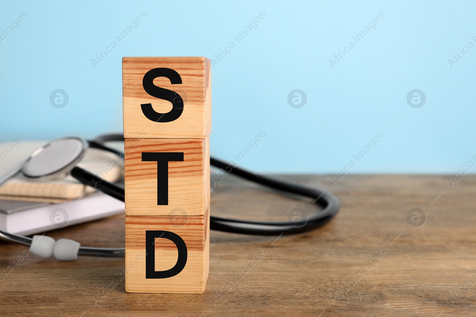 Photo of Abbreviation STD made with cubes on wooden table, space for text