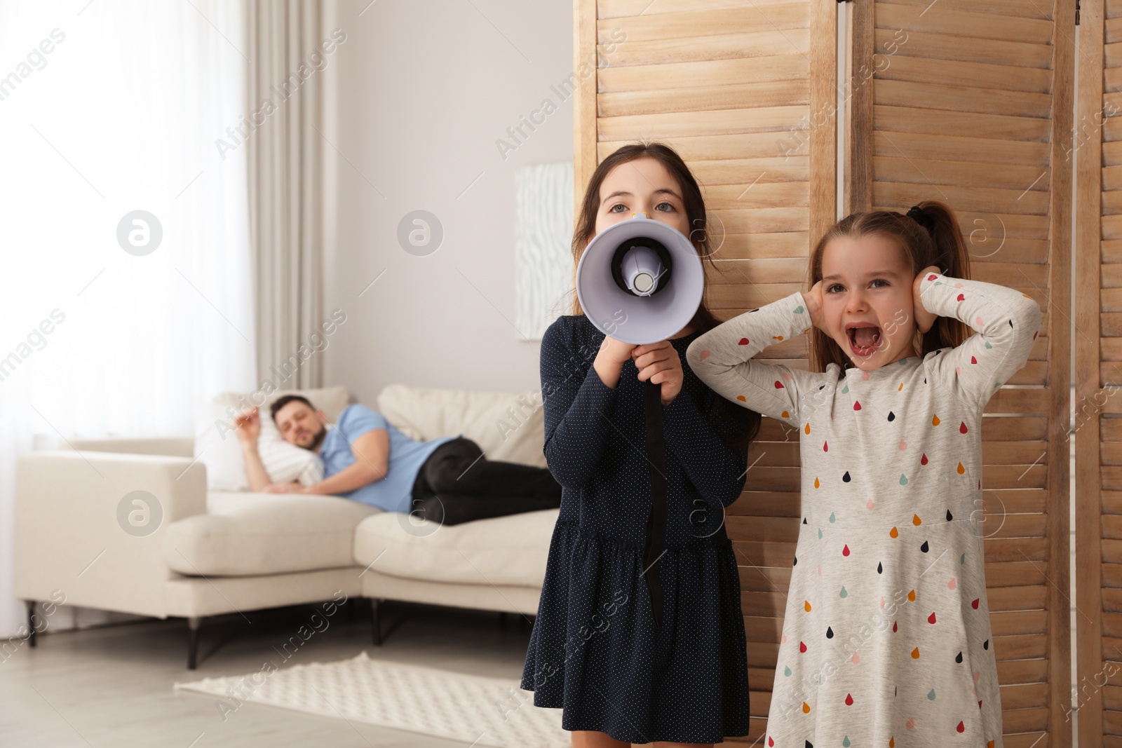 Photo of Cute little children with megaphone waking up their father at home