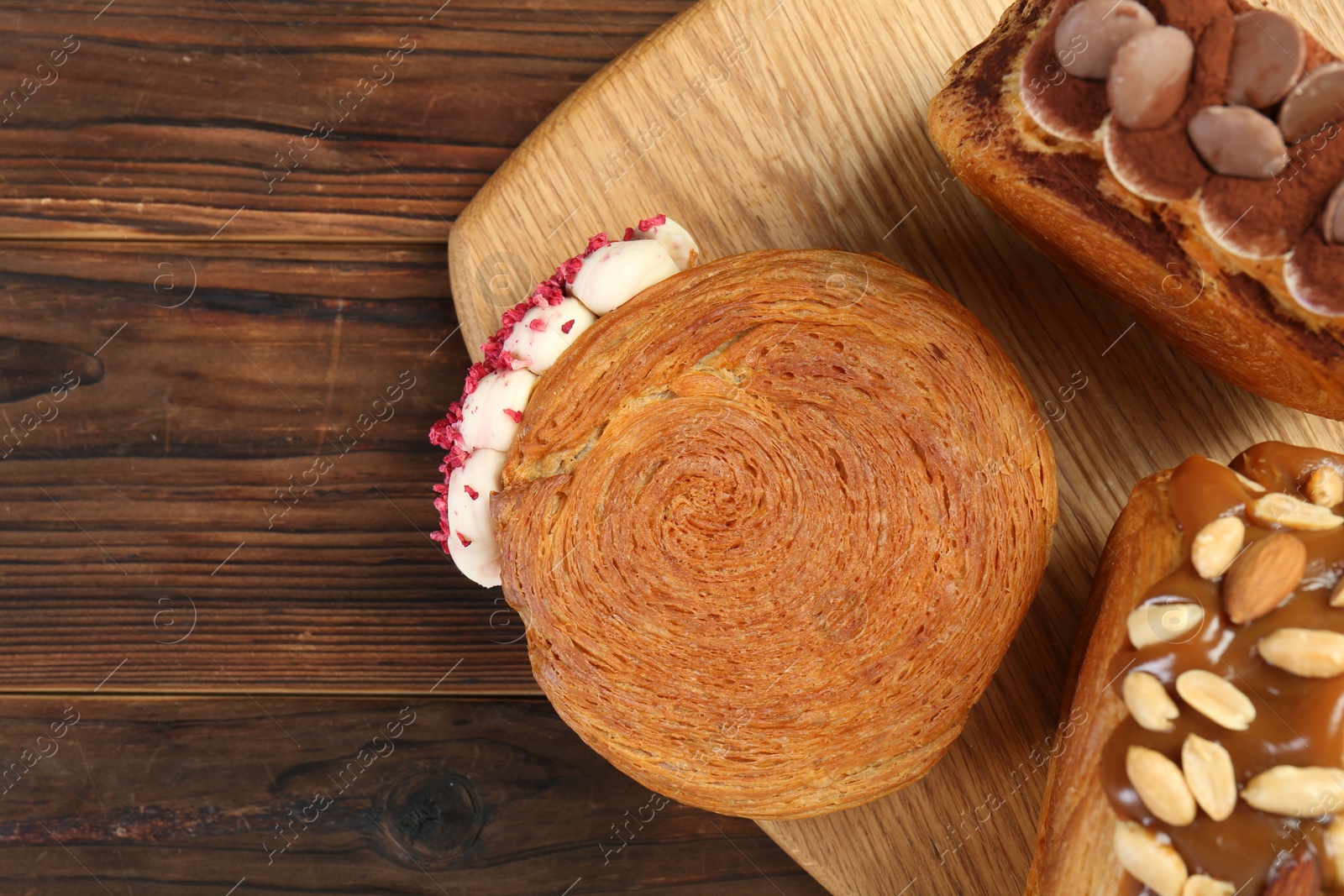 Photo of Tasty puff pastry. Round croissants on wooden table, top view. Space for text