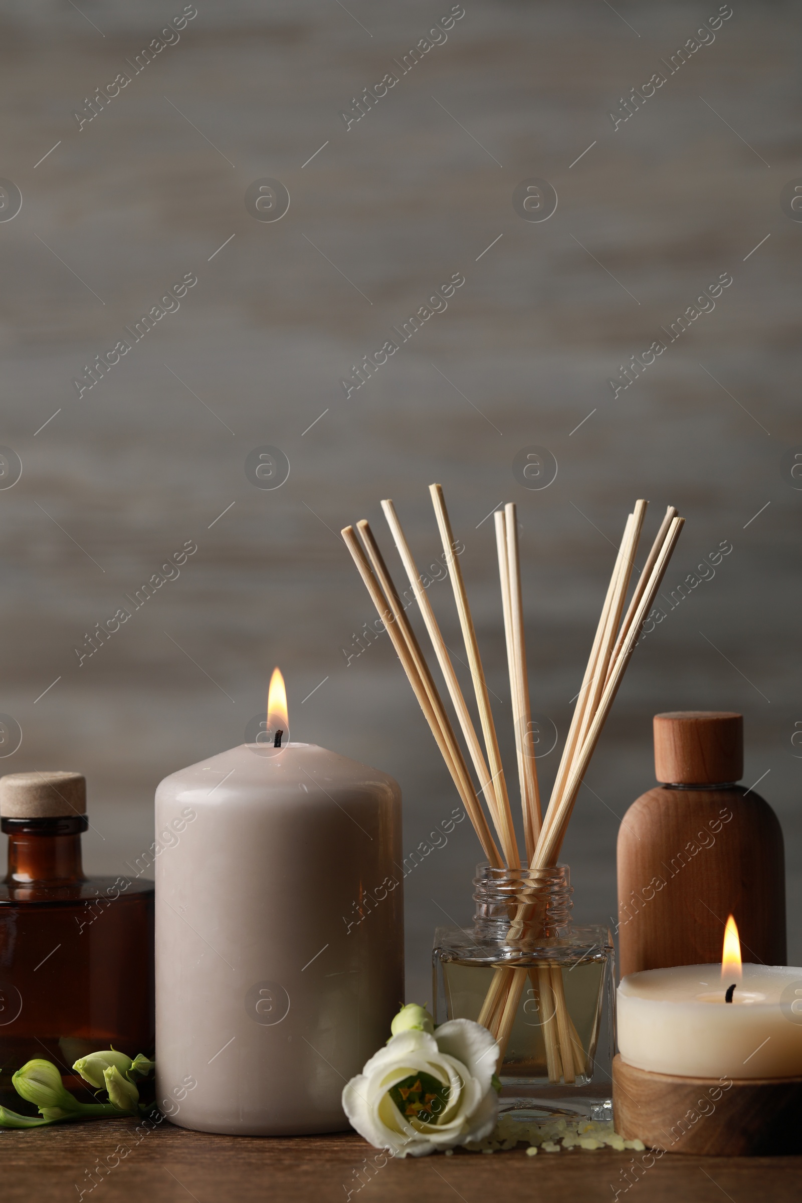 Photo of Beautiful composition with burning candles and different spa products on wooden table