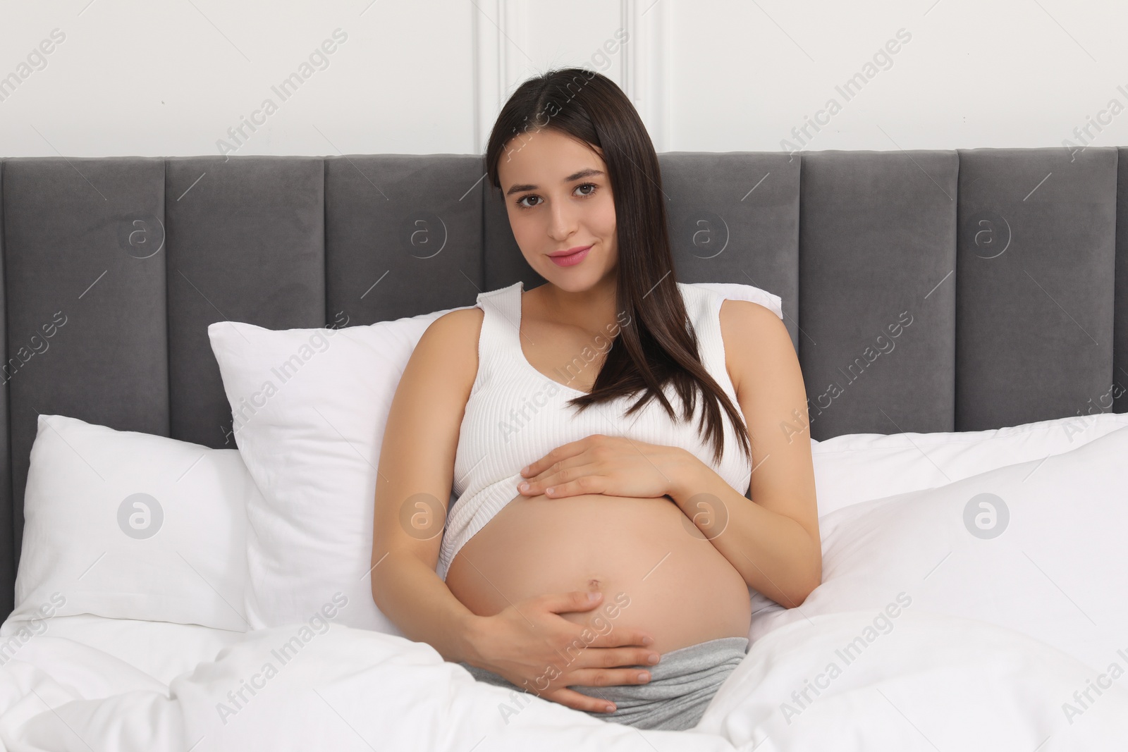 Photo of Beautiful pregnant woman in bed at home