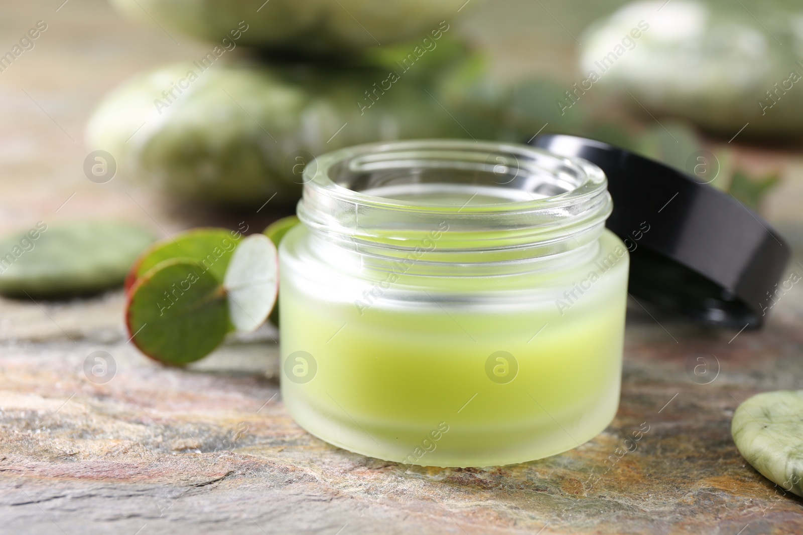 Photo of Jar of cream on textured table, closeup. Body care product