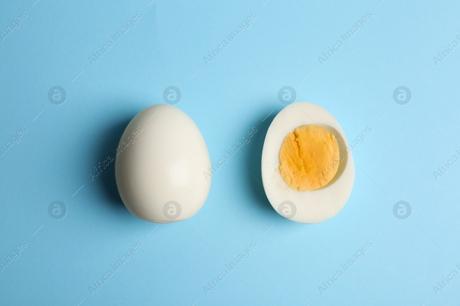 Photo of Fresh hard boiled chicken eggs on light blue background, flat lay