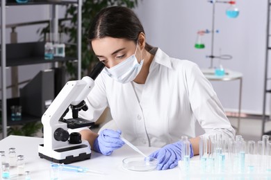 Scientist working with sample at white table in chemical laboratory