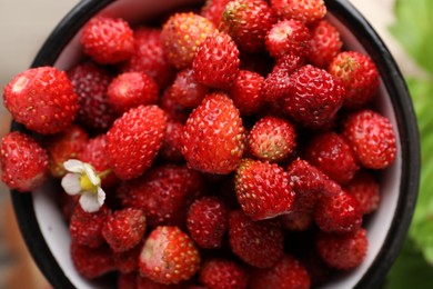 Photo of Fresh wild strawberries in mug, top view