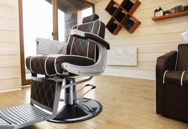 Photo of Stylish barbershop interior with professional armchair and modern wash unit