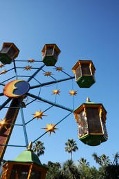 Photo of Beautiful large Ferris wheel against blue sky, low angle view