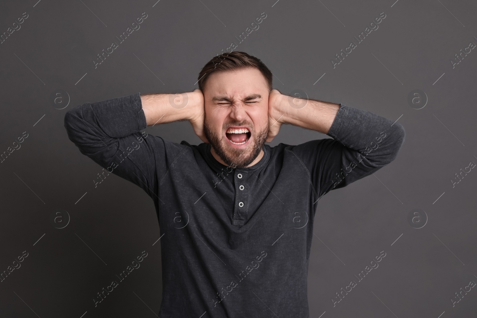 Photo of Portrait of emotional young man on grey background. Personality concept