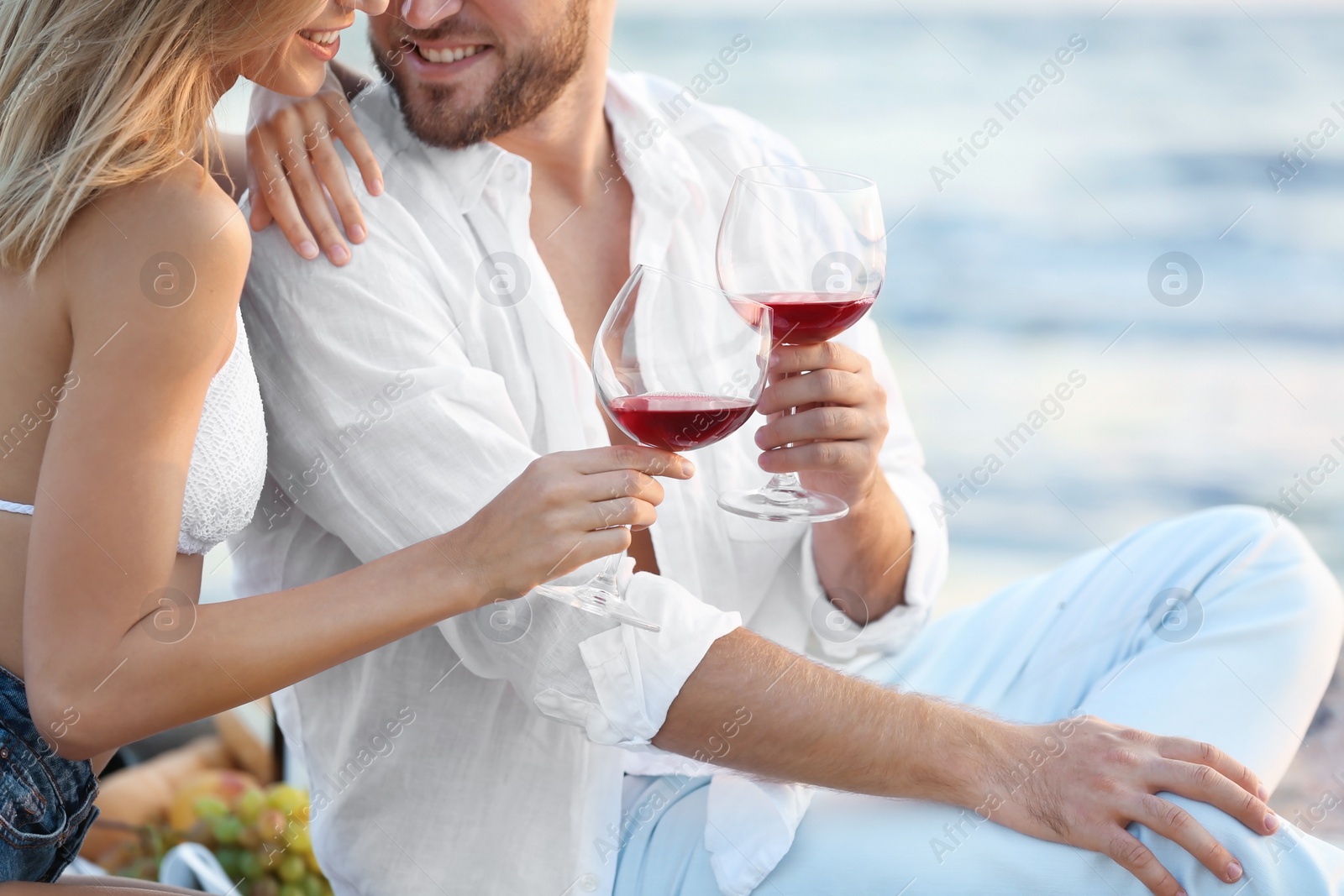 Photo of Young couple with glasses of wine on beach