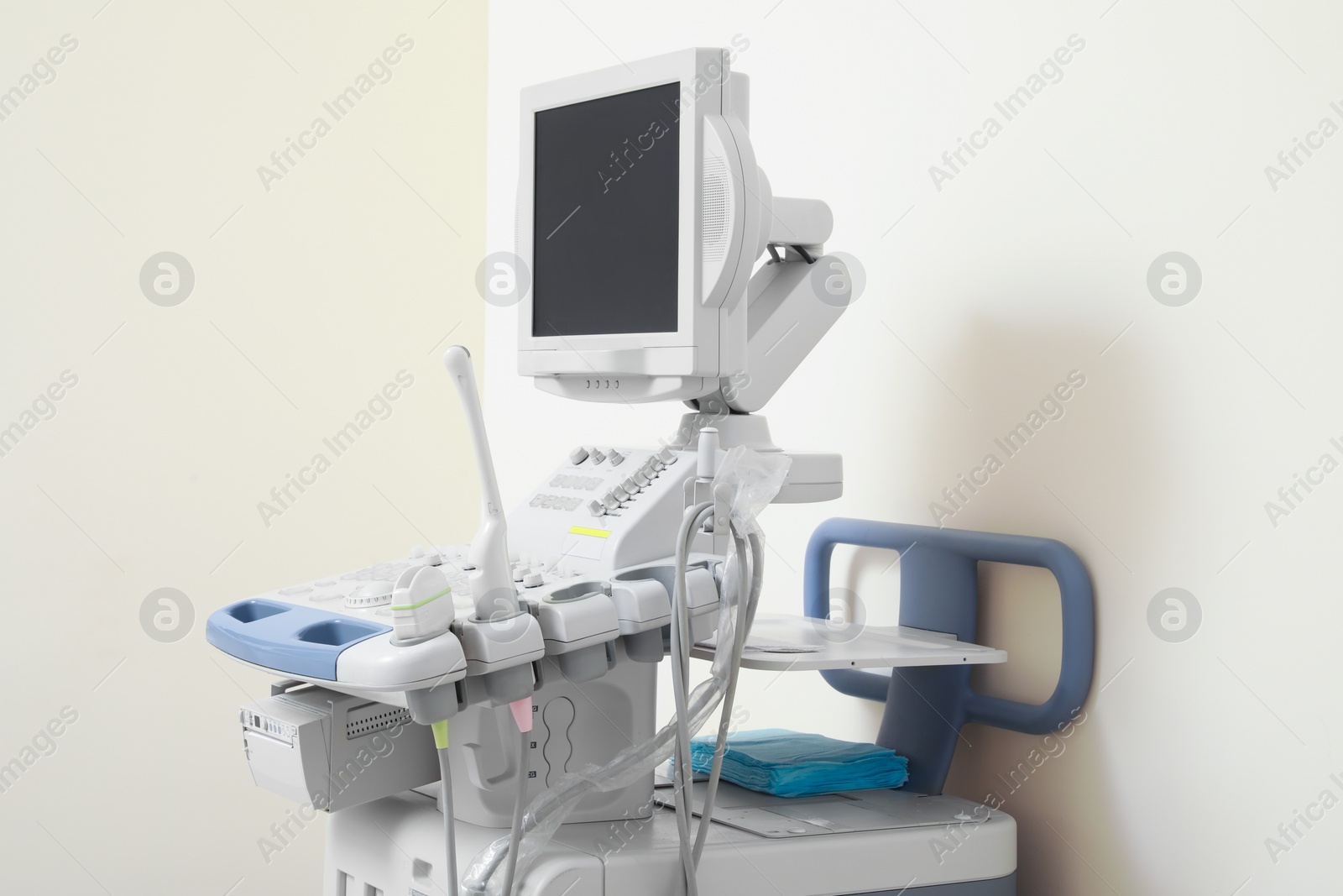 Photo of Ultrasound machine near white wall. Medical equipment