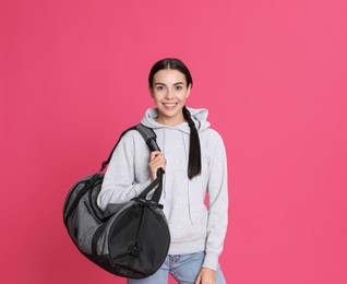 Photo of Beautiful woman with sports bag on pink background