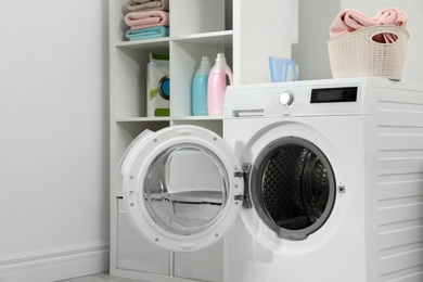 Modern washing machine in laundry room interior