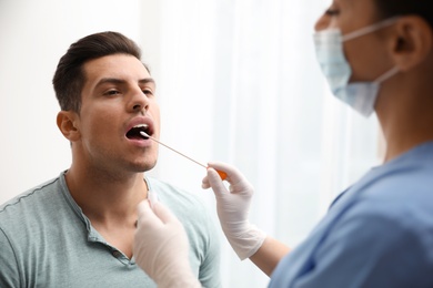 Photo of Doctor taking sample for DNA test from man in clinic