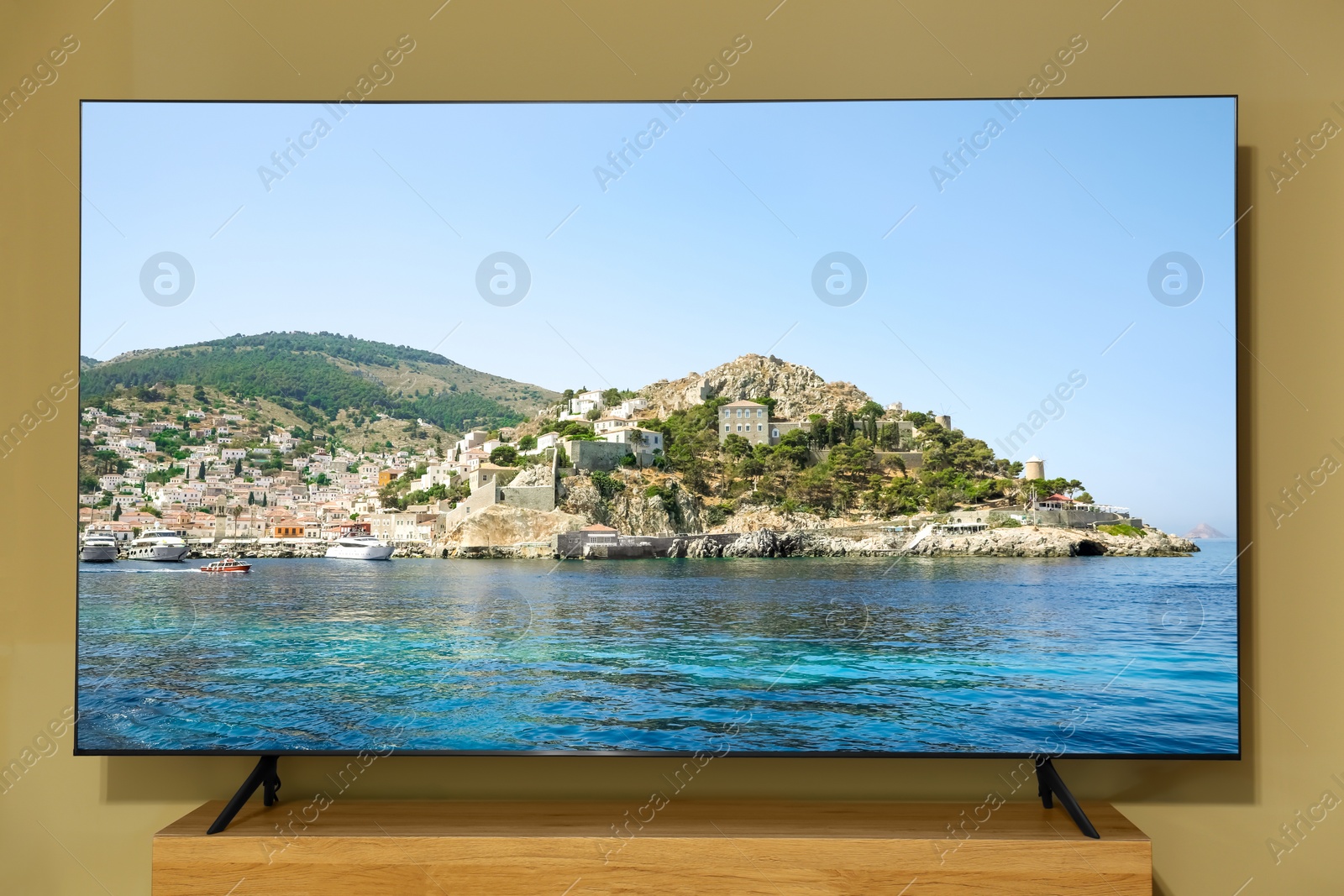 Image of Tv near beige wall. Nature show on screen