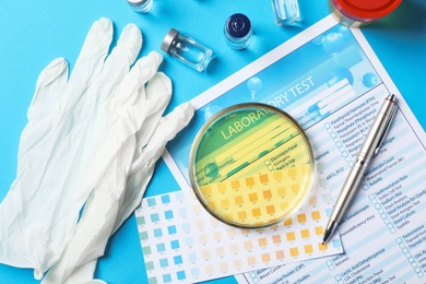 Photo of Flat lay composition with urine sample and test form on color background. Urology concept