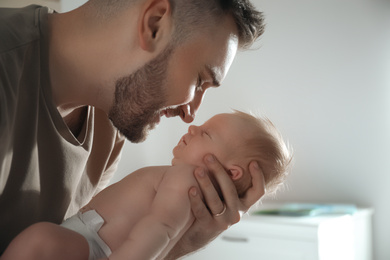 Father with his newborn son at home, closeup