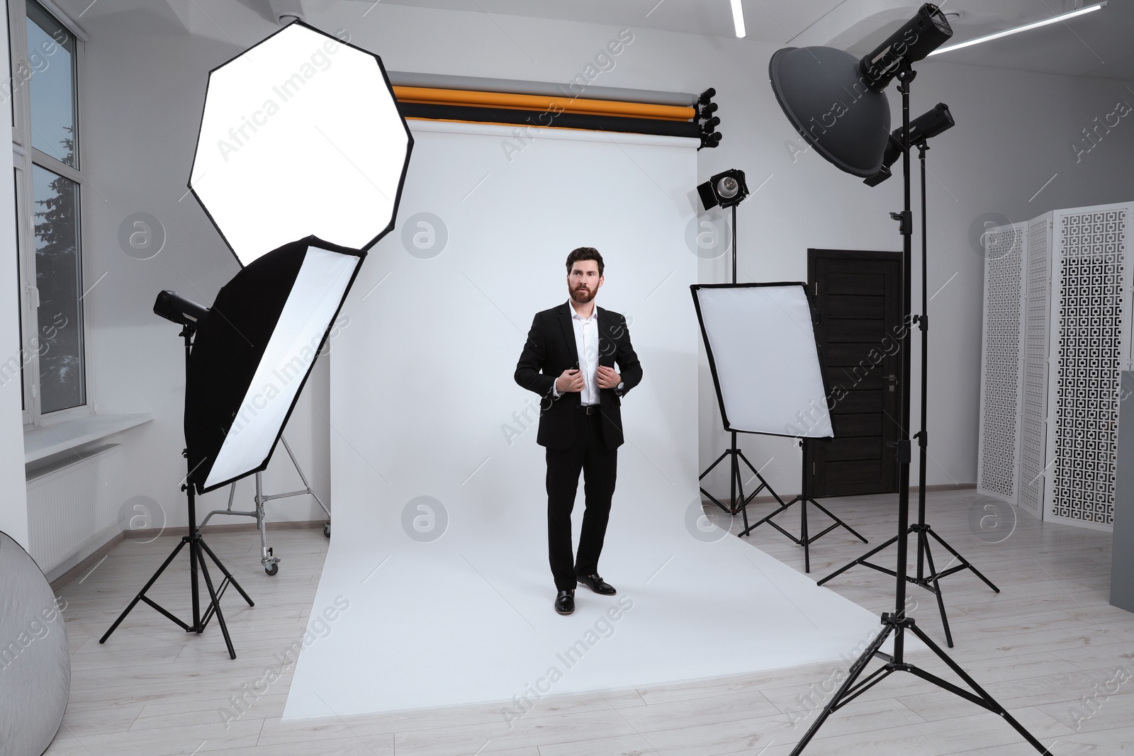 Photo of Handsome model posing in modern studio. Professional photo session