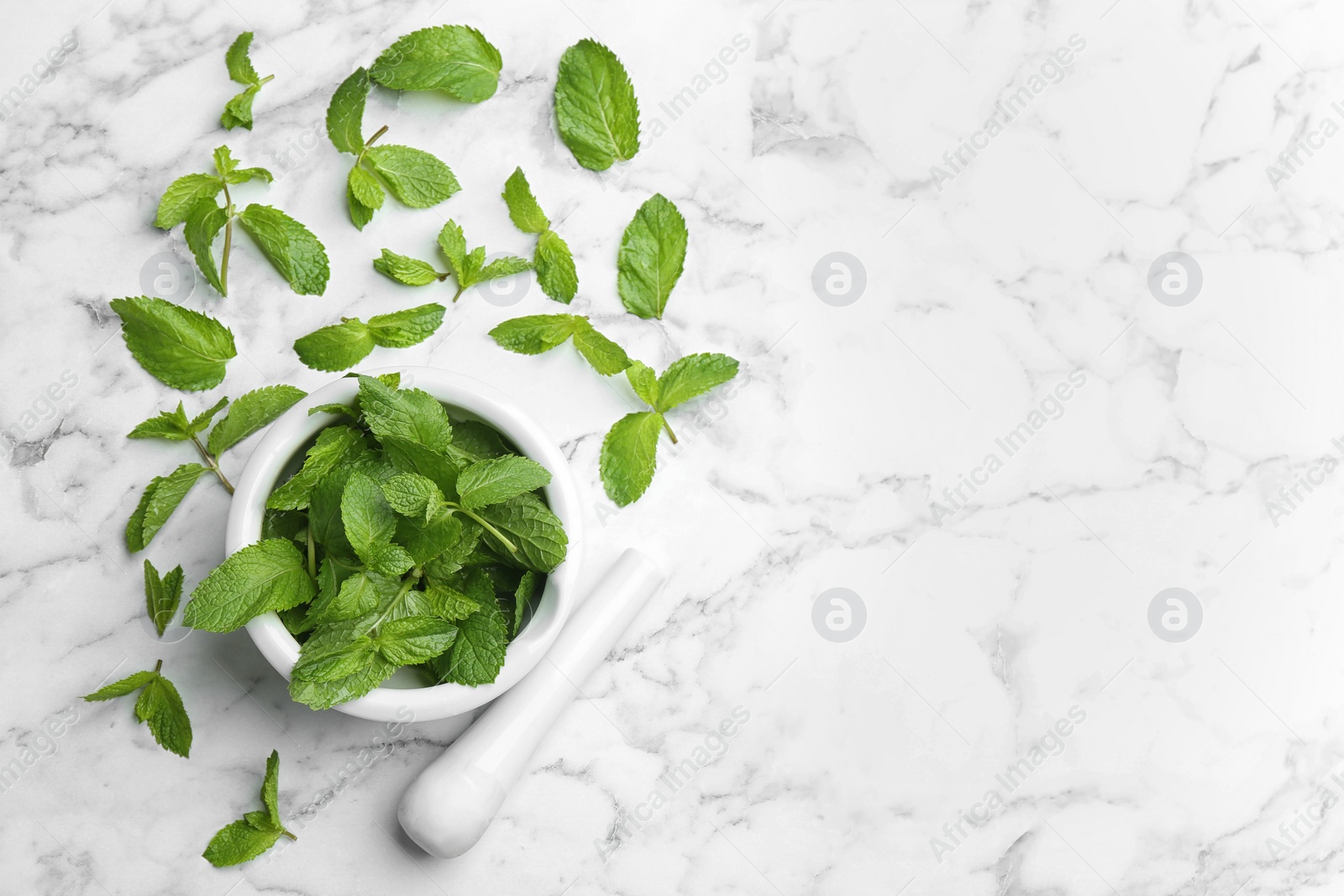 Photo of Fresh mint with mortar and pestle on white marble background, flat lay. Space for text