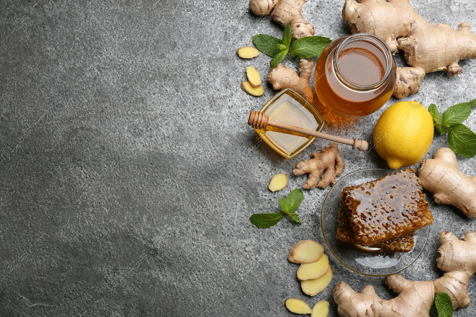 Photo of Ginger and other natural cold remedies on grey table, flat lay. Space for text