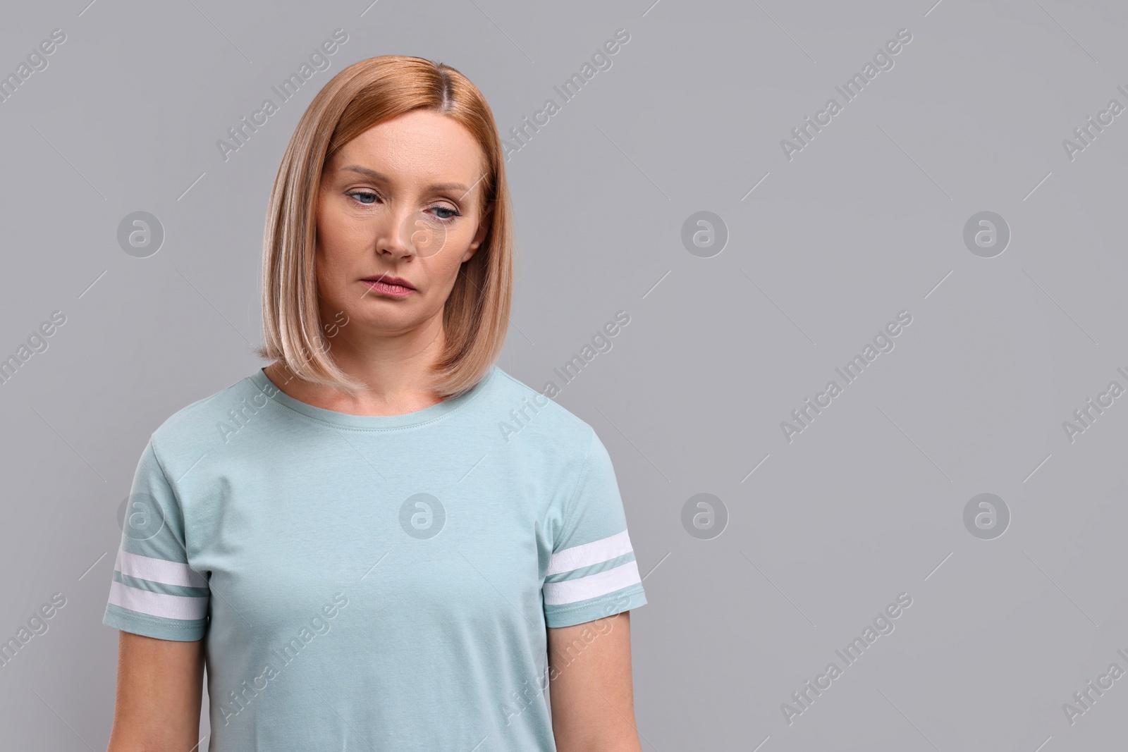 Photo of Portrait of sad woman on grey background. Space for text