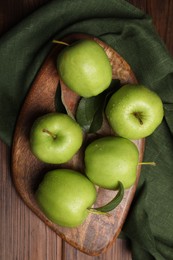 Photo of Ripe green apples with leaves and water drops on wooden table, flat lay