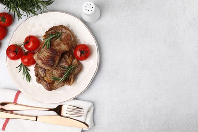Photo of Delicious fried meat with rosemary and tomatoes served on light grey table, flat lay. Space for text