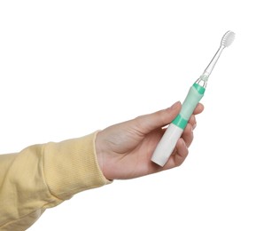 Photo of Woman holding electric toothbrush on white background, closeup