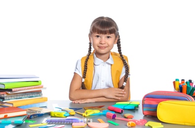 Photo of Schoolgirl at table with stationery against white background