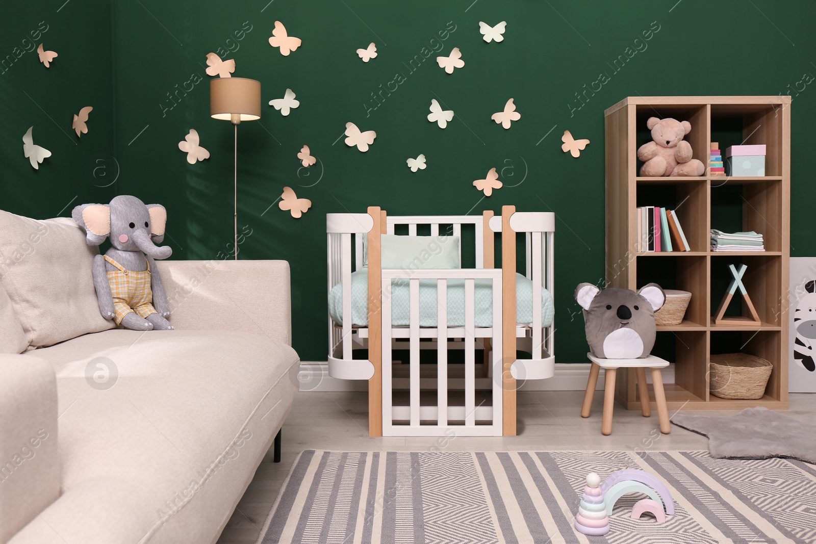 Photo of Beautiful baby room interior with comfortable crib and toys