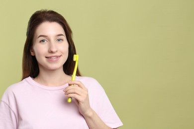 Portrait of smiling woman with dental braces and toothbrush on light green background. Space for text