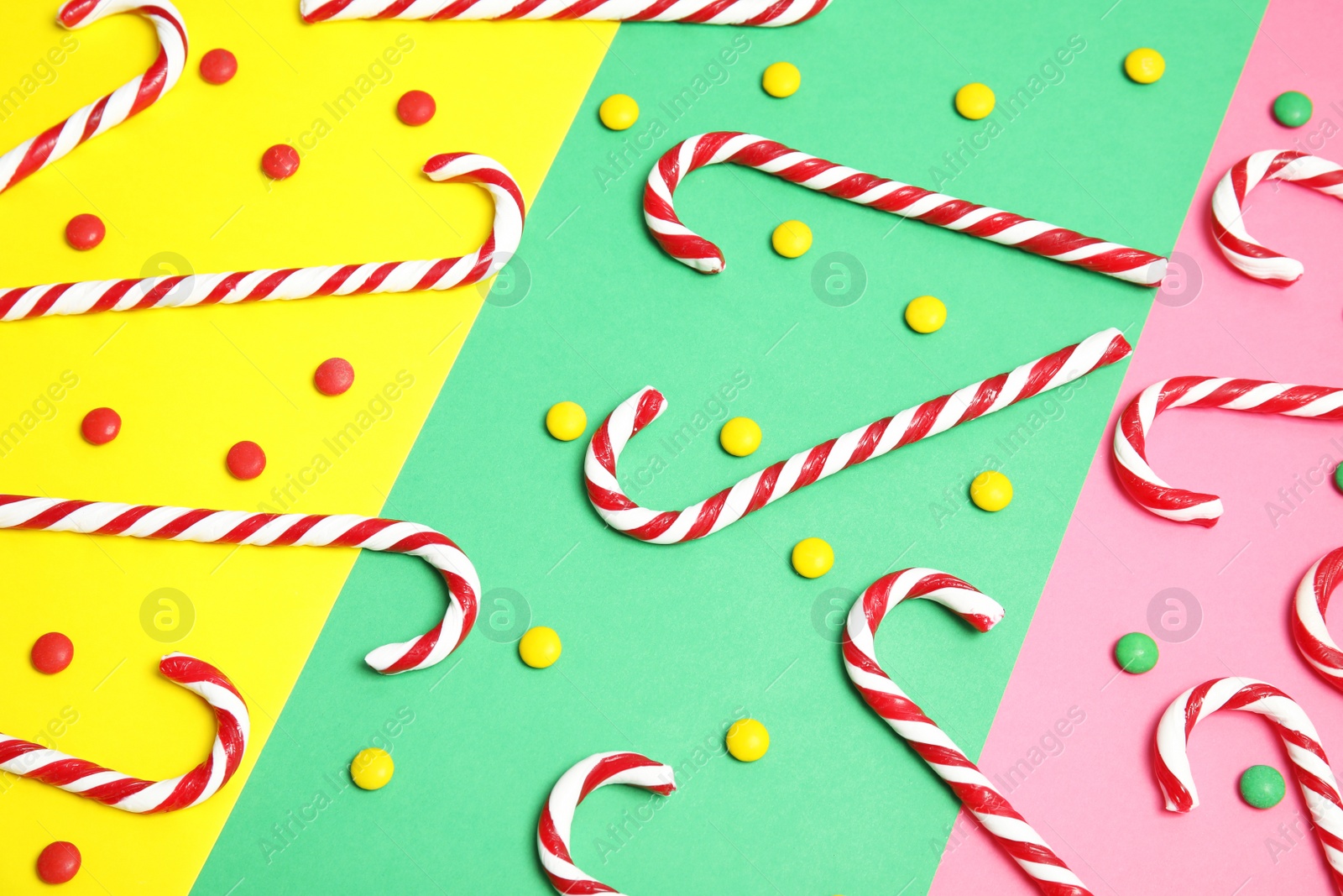 Photo of Flat lay composition with tasty candy canes on color background