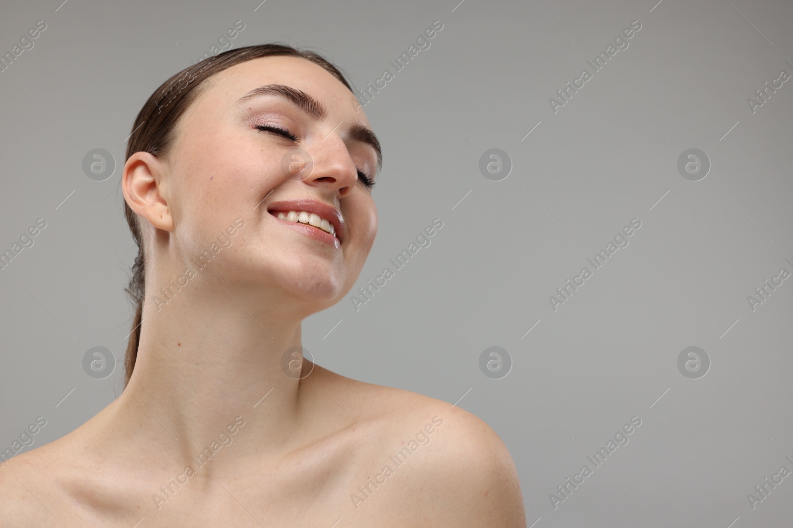 Photo of Portrait of smiling woman on grey background. Space for text