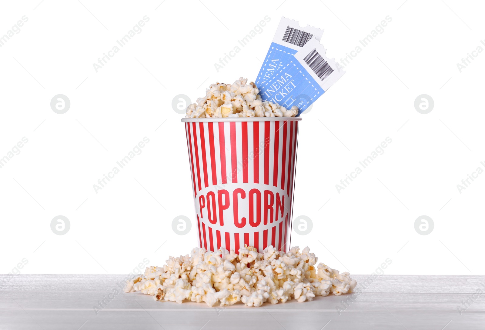 Photo of Delicious popcorn with tickets on wooden table against white background