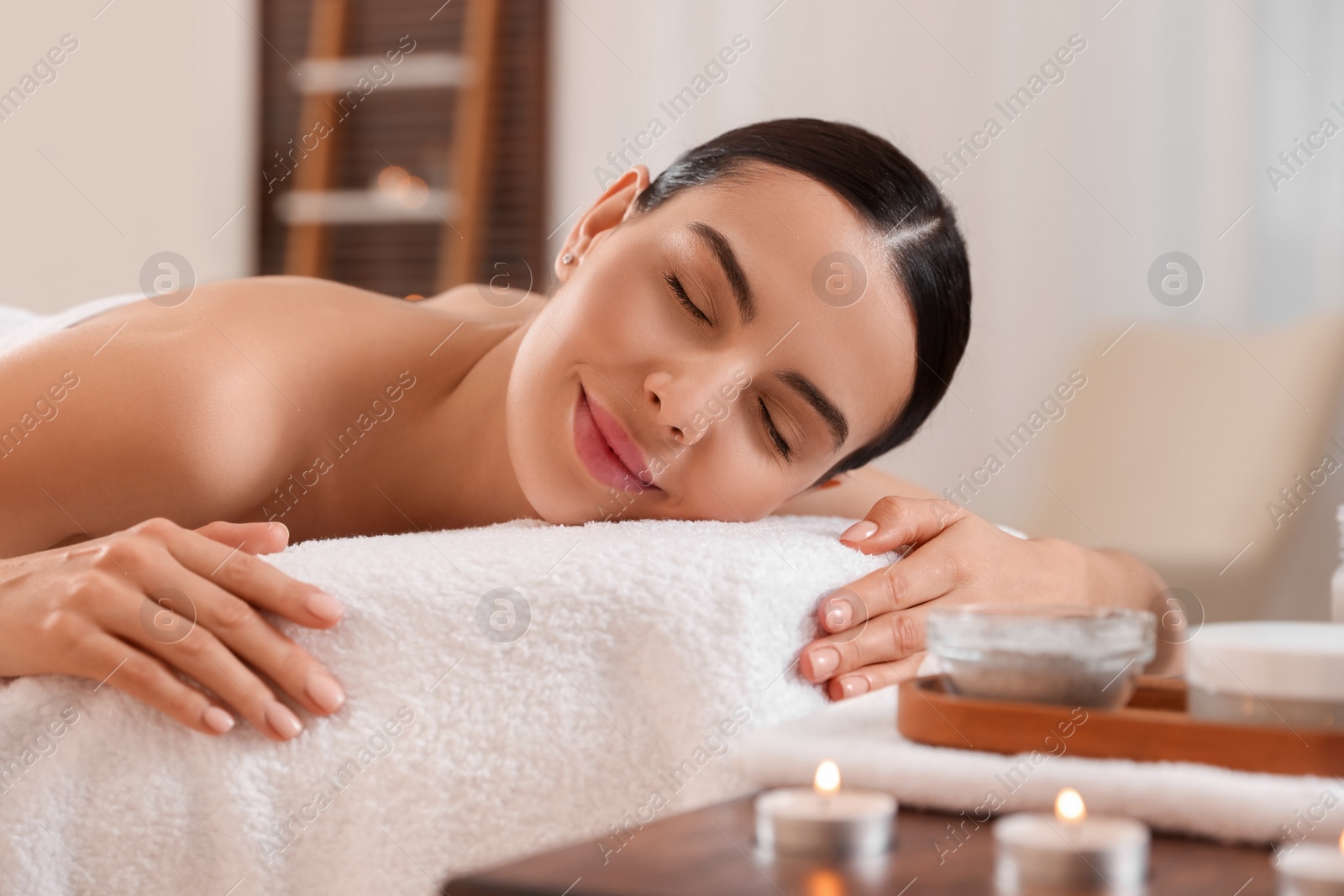 Photo of Young woman resting on massage couch in spa salon