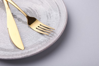 Photo of Setting with stylish cutlery on grey table, closeup. Space for text