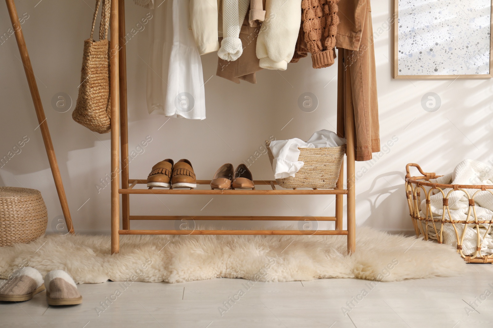 Photo of Rack with stylish shoes and women's clothes in dressing room. Modern interior design