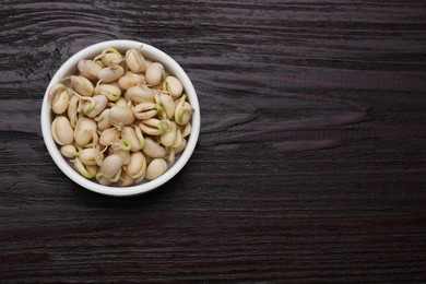 Photo of Sprouted kidney beans in bowl on dark wooden table, top view. Space for text