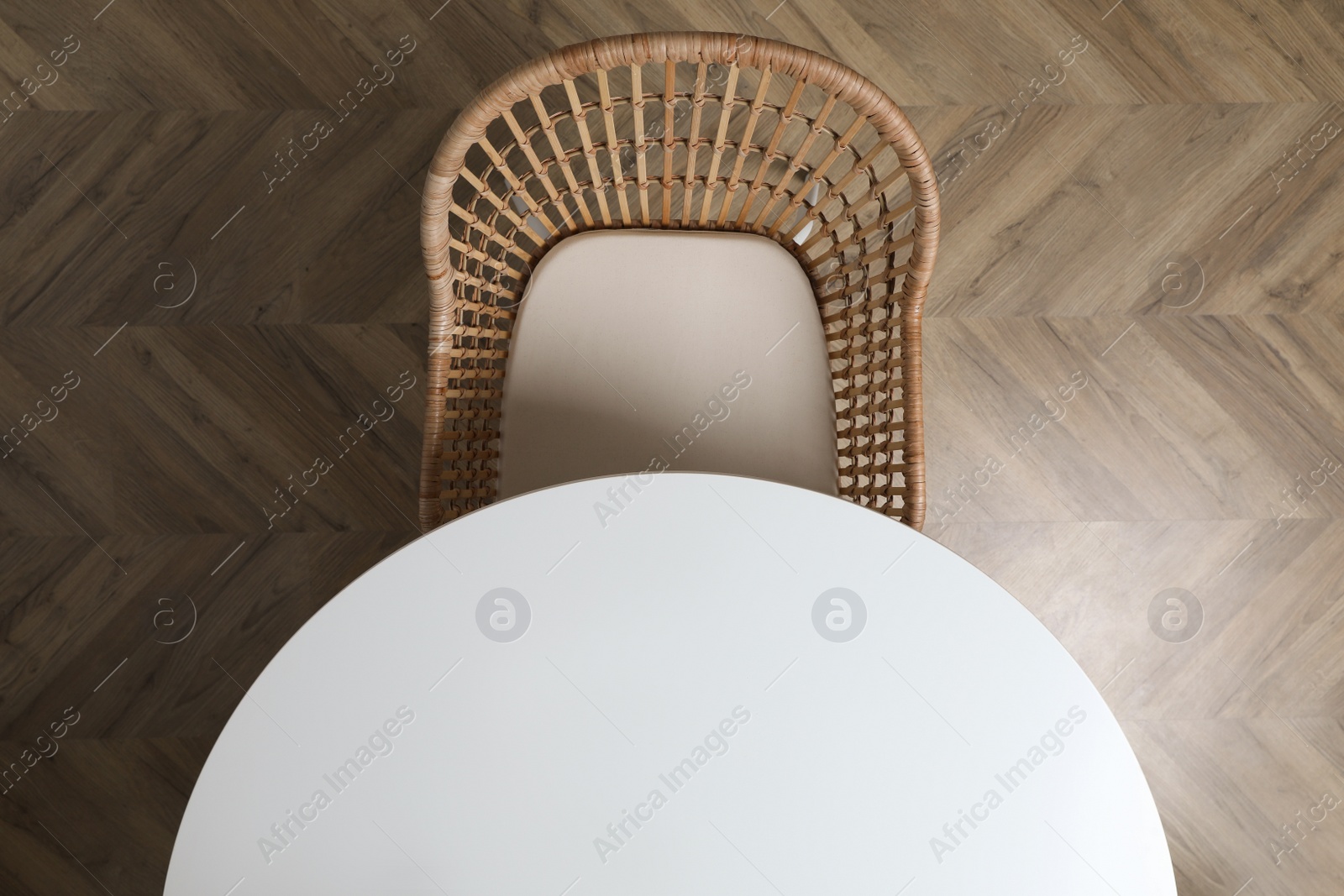 Photo of Round table and wicker armchair indoors, top view