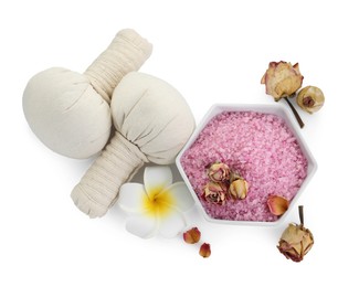 Photo of Bowl of pink sea salt, herbal massage bags, plumeria flower and dry roses isolated on white, top view. Spa treatment