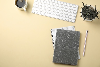 Blogger's workplace with notebooks and keyboard on color background, flat lay. Space for text