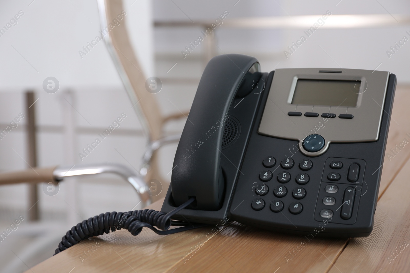 Photo of Desktop telephone on wooden table in office, space for text. Hotline service