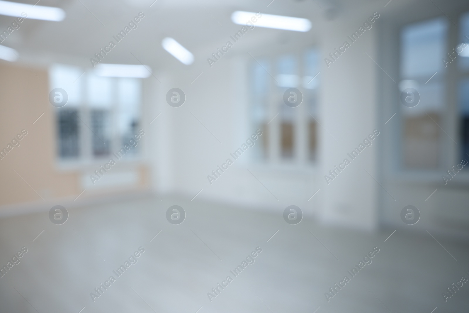 Photo of Blurred view of empty room with windows and light walls