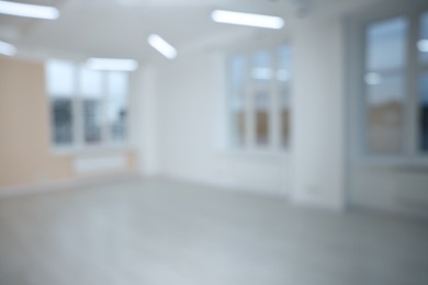 Blurred view of empty room with windows and light walls