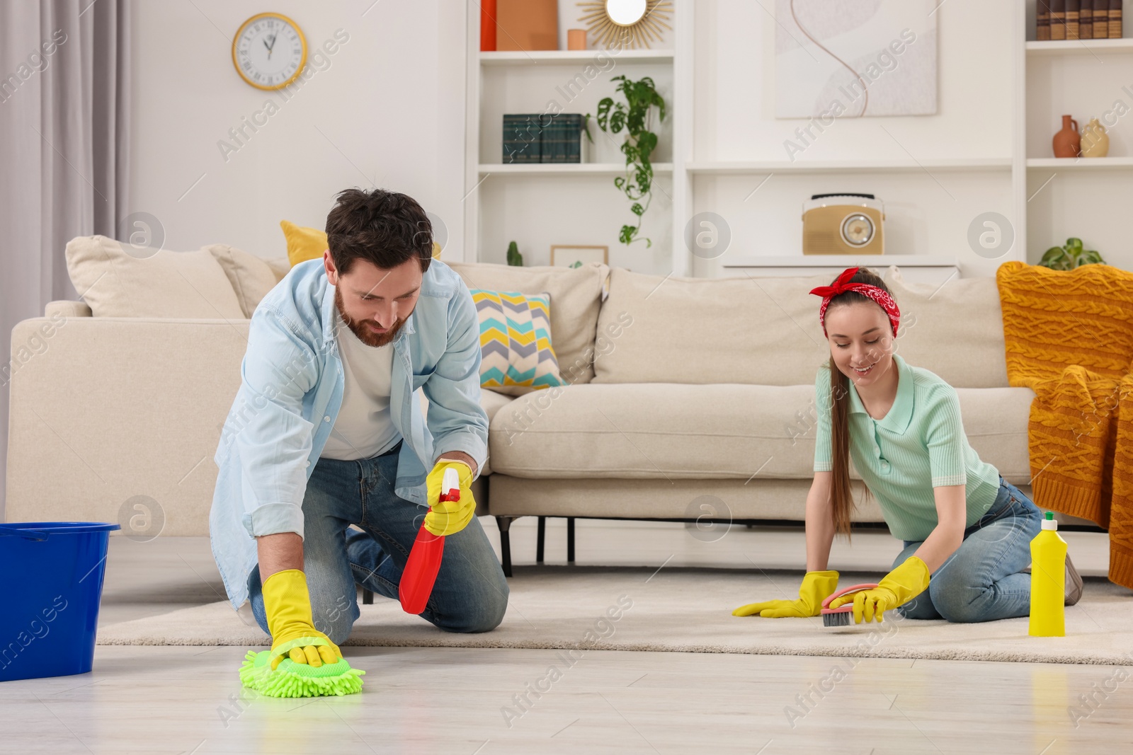 Photo of Spring cleaning. Couple tidying up living room together