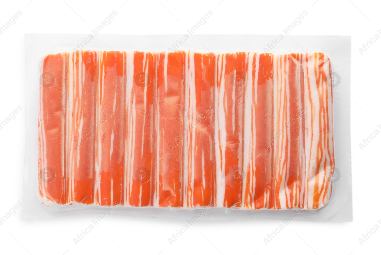 Photo of Delicious crab sticks in plastic packaging isolated on white, top view