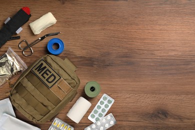 Photo of Military first aid kit on wooden table, flat lay. Space for text